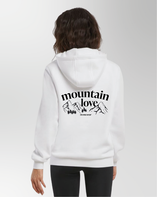 Dame trägt Hoodie oder Pullover in weiß mit Bergmotiv am Rücken.