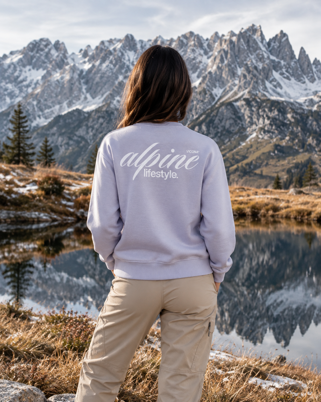 Dame steht in lila Sweater vor einem Berg in Österreich